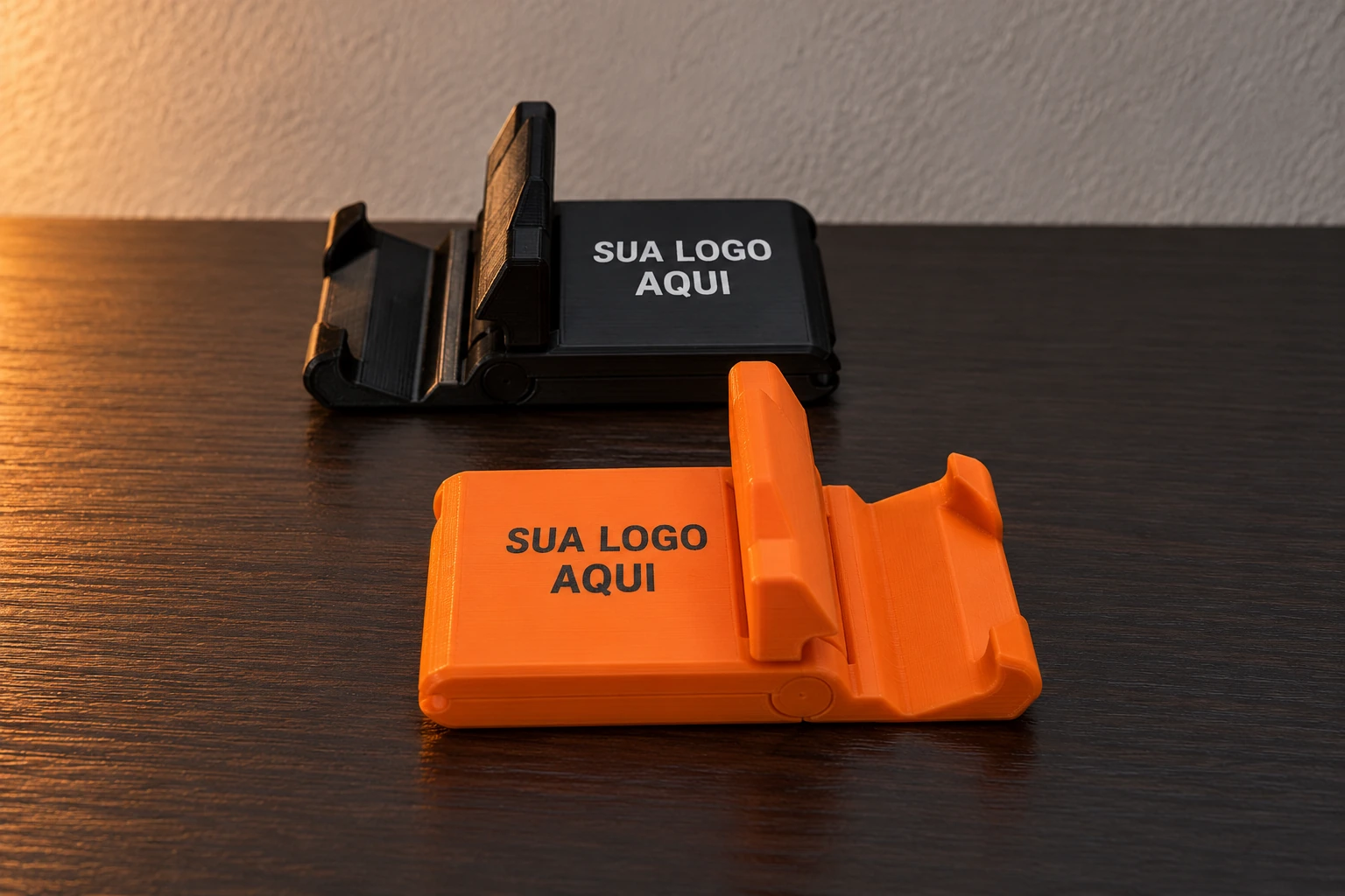 Exemplo ilustrativo de suportes de celular preto e laranja com a frase Sua logo aqui